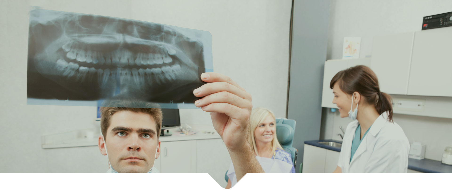 A dentist examining the X-Ray of a patient's jaw