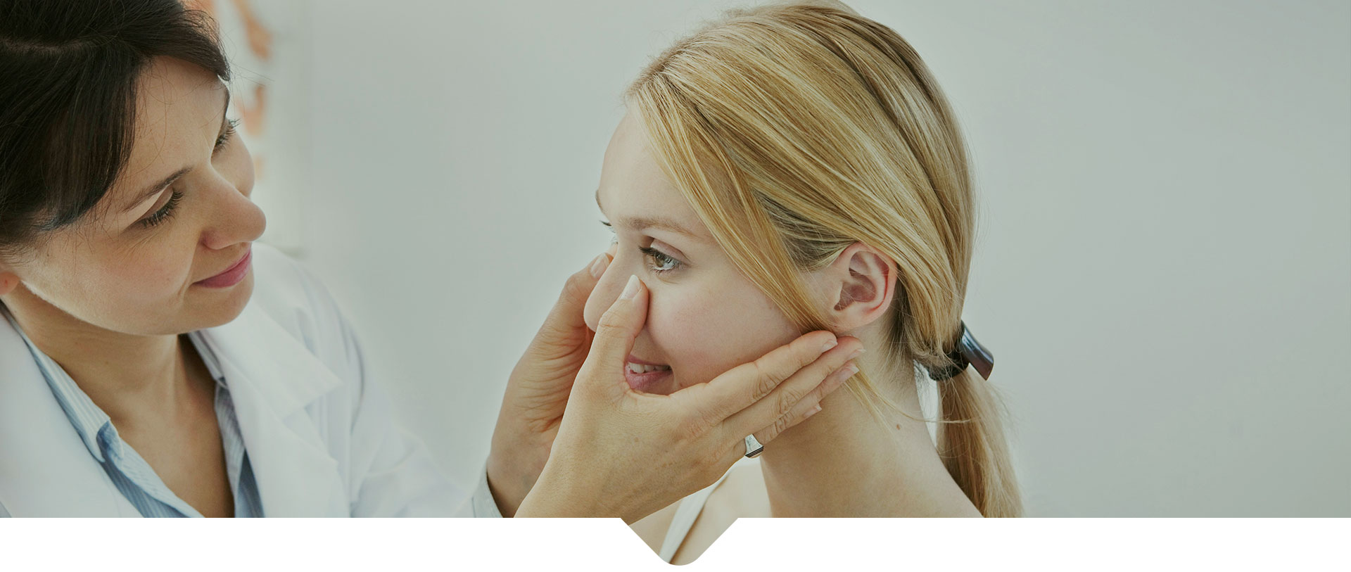 A doctor examining a female patient's nose
