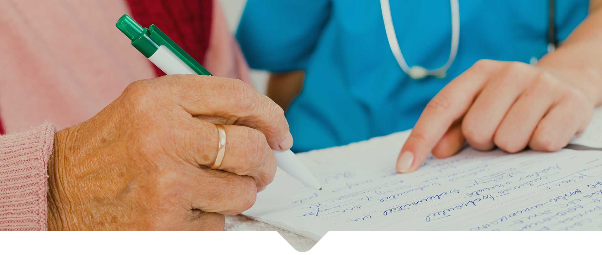 An old patient putting her signature on medical form with the help the staff